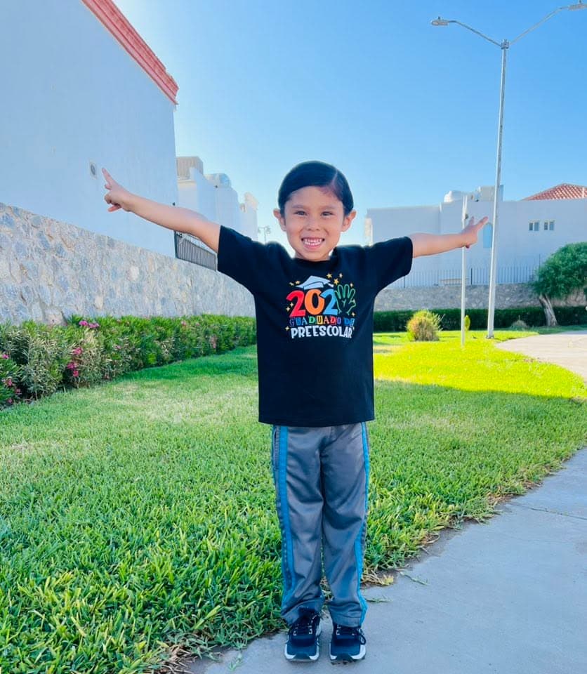 A child with arms spread wide outdoors in custom Marcomania apparel